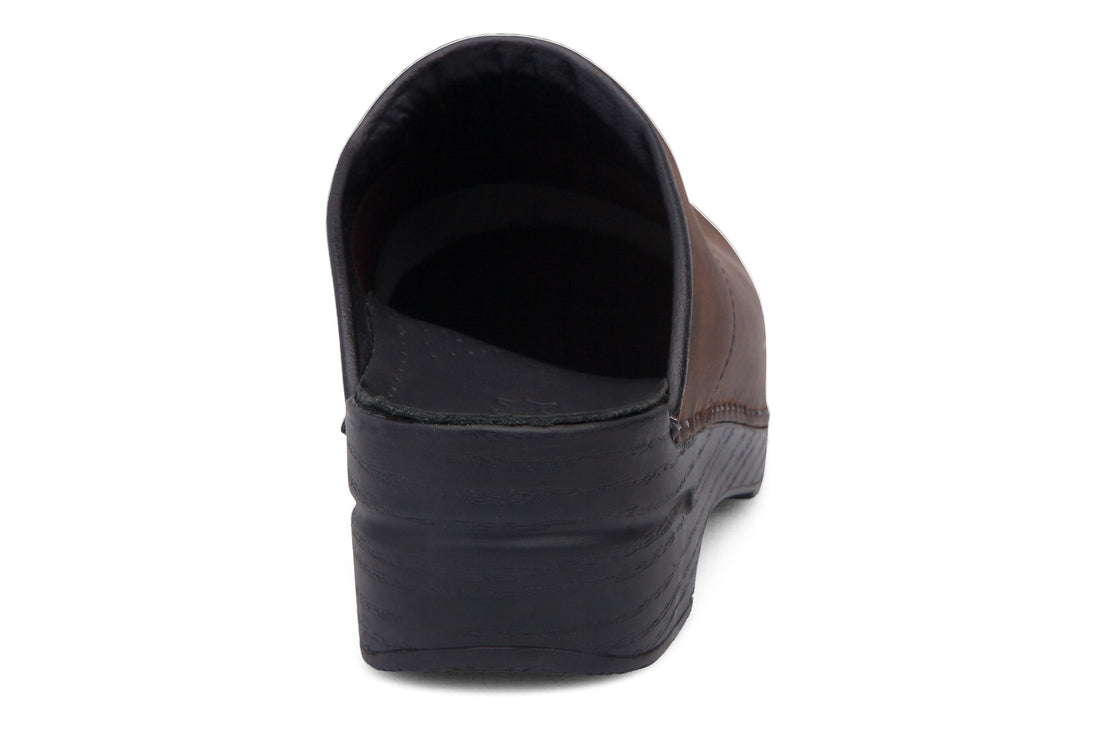 Clog, brown leather, closed toe, open heel; Dansko Karl mens with plantar fasciitis support and black sole, side view.