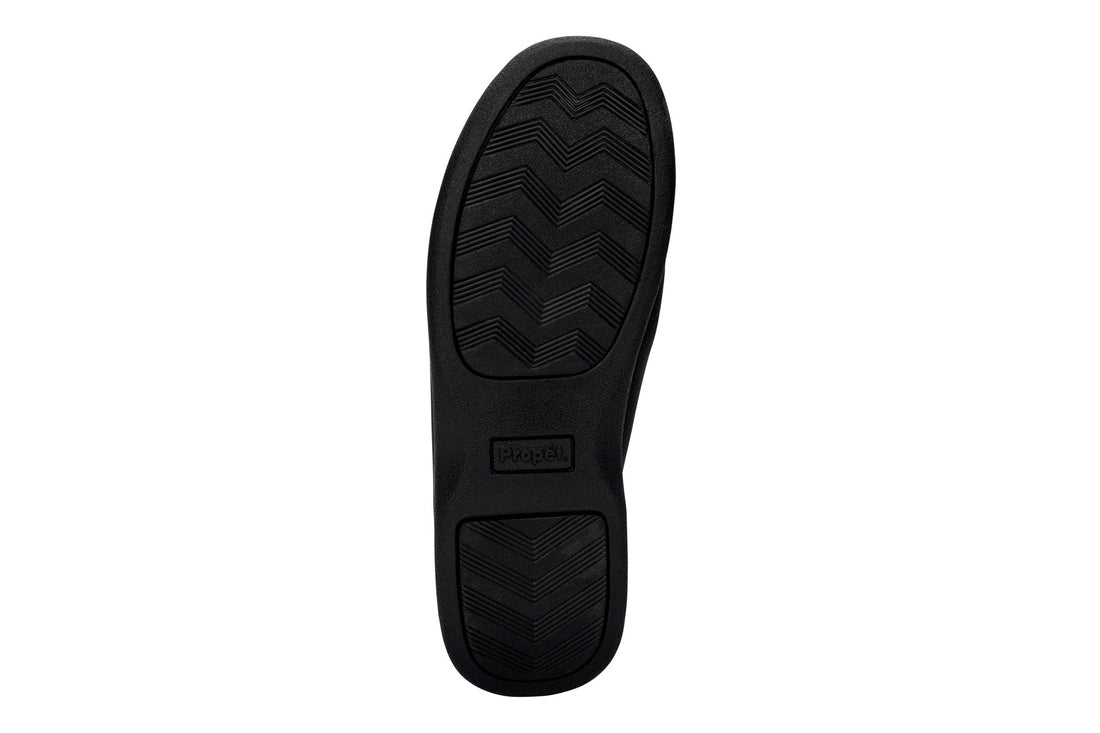 Shoe with black chevron rubber sole, Propet logo, for Cush N Foot slippers; features removable insoles for comfort.
