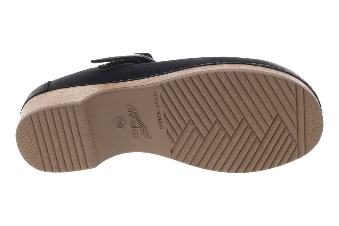 Mule shoe, black leather, Dansko Berry with side buckle, wooden sole, white stitching. Comfort features not visible.