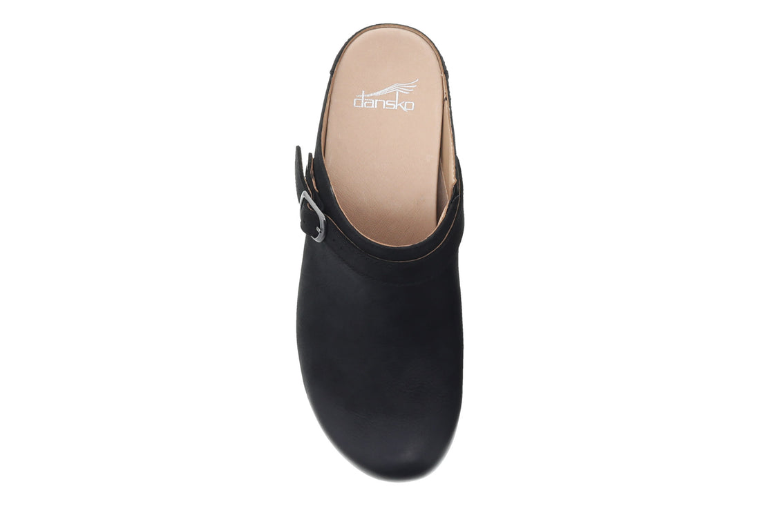 Mule shoe, black leather, Dansko Berry with side buckle, wooden sole, white stitching. Comfort features not visible.
