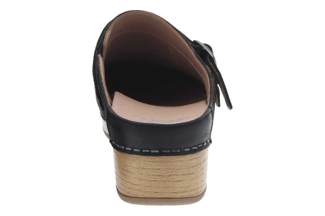 Mule shoe, black leather, Dansko Berry with side buckle, wooden sole, white stitching. Comfort features not visible.